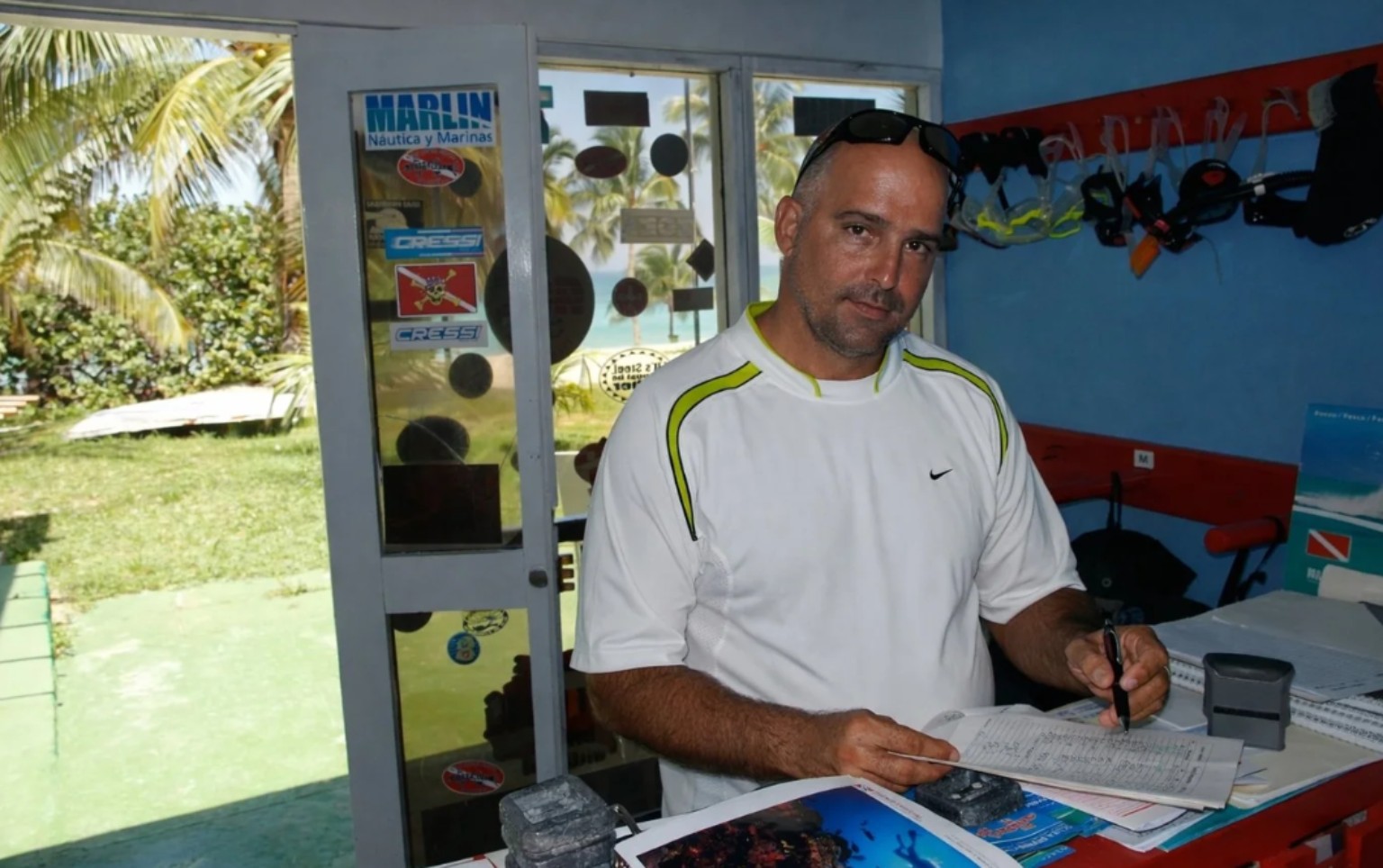Manolo in his dive centre in Cuba, surrounded by his prints